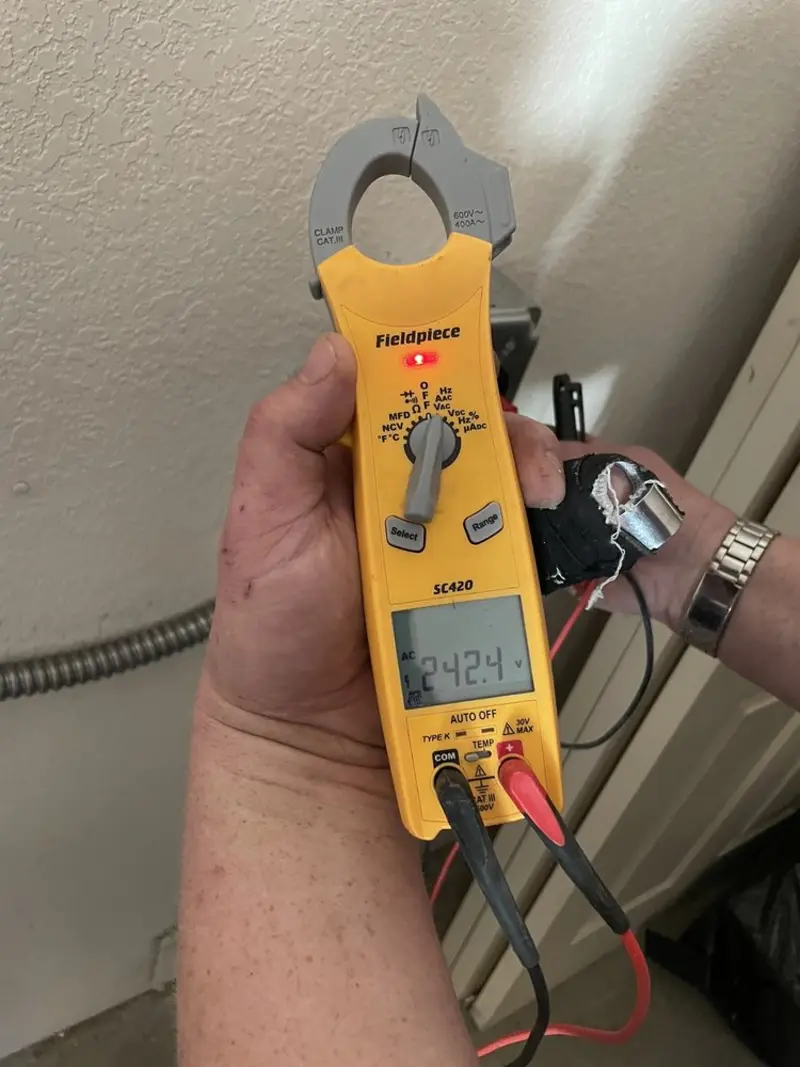 Voltage testing with clamp meter during Ceiling Fan Installation in August